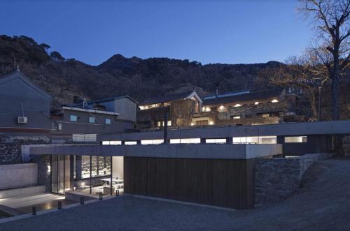 a modern house with a view of a mountain at Brickyard Retreat at Mutianyu Great Wall Adjoin to Mutianyu Great Wall - Room with the View of Great Wall - Chinese massage experience - Vehicle Shuttle Service - International Catering - SPA& Nail Beauty Facilities in Huairou