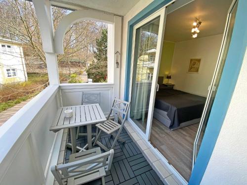 een veranda met 2 stoelen, een tafel en een bed bij Haus Holstein Whg 07 mit Balkon in Ostseebad Sellin