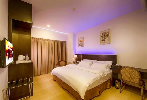 a bedroom with a large bed with purple lighting at E Red Hotel Alma Cosmo in Bukit Mertajam