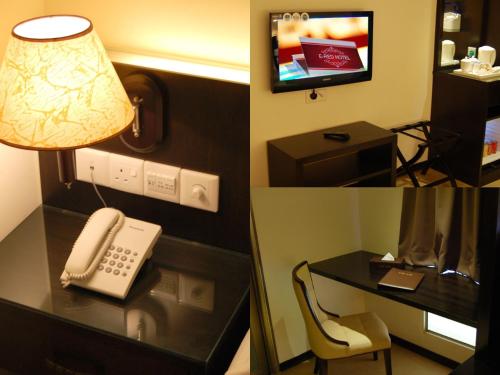 a hotel room with a phone and a desk with a lamp at E Red Hotel Alma Cosmo in Bukit Mertajam