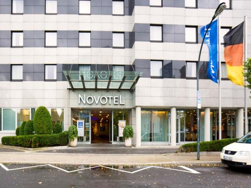 a novation building with flags in front of it at Novotel Düsseldorf City West in Düsseldorf