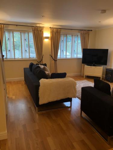 a living room with a couch and a flat screen tv at Kellsboro Corner in Fairford