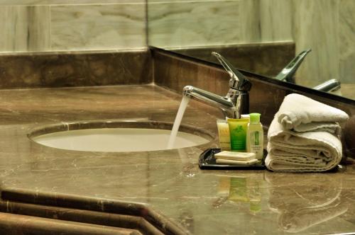 La salle de bains est pourvue d'un lavabo et d'un robinet avec de l'eau. dans l'établissement Hotel Lopez Campeche, à Campeche