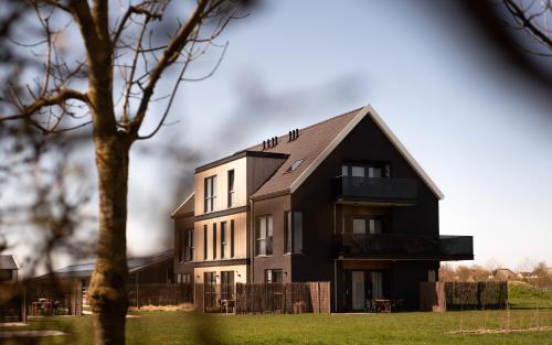 a black and white house with a tree at Domburg Holiday Resort in Domburg