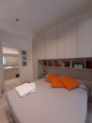 a bedroom with a large bed with two orange pillows at BMP APARTMENT GIOIOSA 2 giardino vista Lago Maggiore in Belgirate