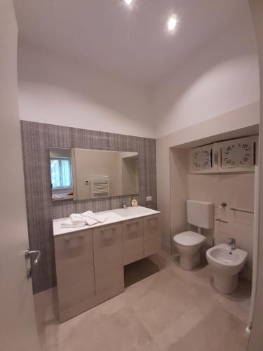 a bathroom with a sink and a toilet and a mirror at BMP APARTMENT GIOIOSA 2 giardino vista Lago Maggiore in Belgirate