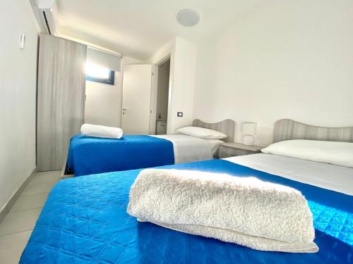two beds in a room with blue and white at Galatea House in Marinella di Selinunte