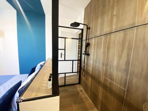a bedroom with a bed and a lamp on a wall at Capsule Gaming balnéo & billard & babyfoot & sauna 2 chambres in Valenciennes