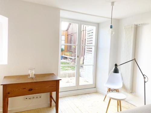 a white room with a desk and a window at Haus Münsterblick in Reichenau