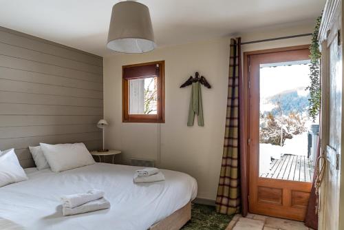- une chambre avec un lit, une fenêtre et une porte dans l'établissement Chalet Lunar, aux Gets