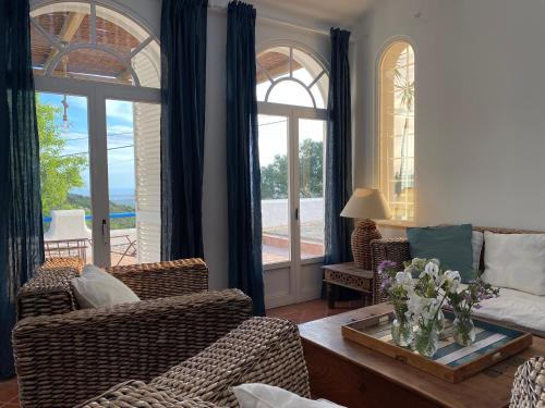 a living room with a couch and chairs and windows at B&B Casa do Cerro in Moncarapacho
