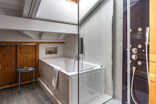 La salle de bains est pourvue d'une douche et d'une baignoire. dans l'établissement Chalet Lunar, aux Gets