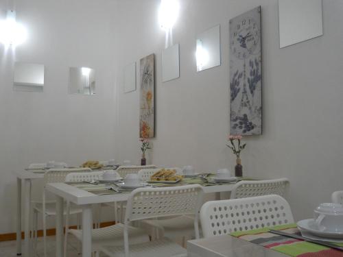 una sala da pranzo bianca con tavoli bianchi e sedie bianche di B&B Cielo & Mare a Pozzallo