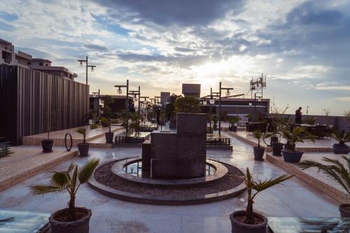 a fountain in the middle of a plaza with palm trees at Trivelles Executive Suites Islamabad in Islamabad