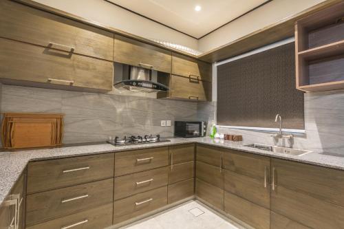 a large kitchen with wooden cabinets and a sink at Trivelles Executive Suites Islamabad in Islamabad