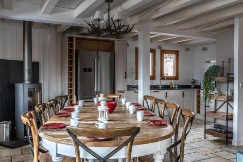 une salle à manger avec une grande table et des chaises en bois dans l'établissement Chalet Lunar, aux Gets