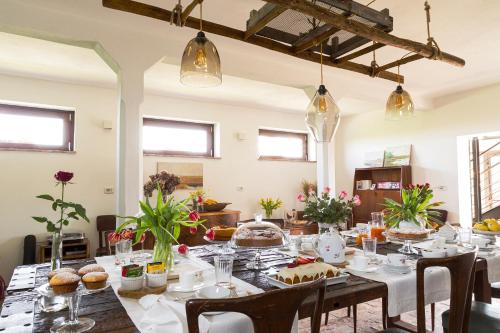 una sala da pranzo con tavolo e cibo di Bed & Breakfast Corte Zen ad Adria