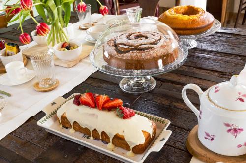 Bed & Breakfast Corte Zen في أدريا: طاولة عليها كيكة وفراولة