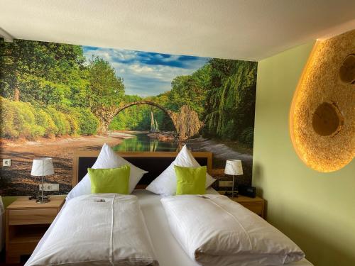 a bedroom with two beds and a painting of a bridge at Berghotel Talblick in Holzhau