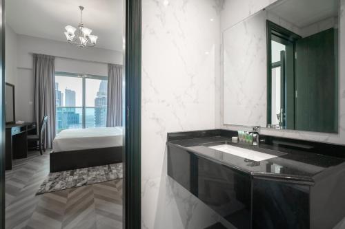a bathroom with a sink and a large mirror at Luton Vacation Homes - Elite Business Bay Residence in Dubai