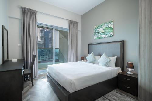 a bedroom with a large bed and a window at Luton Vacation Homes - Elite Business Bay Residence in Dubai