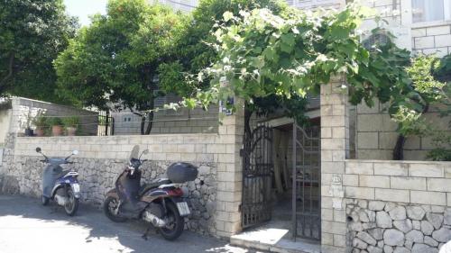 duas scooters estacionadas ao lado de um edifício de tijolos em Apartment Wild Orange em Dubrovnik