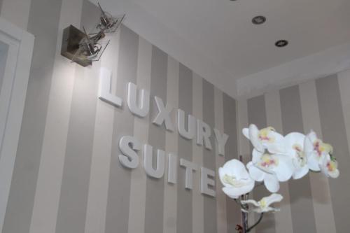 a sign on a wall with white flowers on it at B&B Pescara Centro Luxury Suite in Pescara