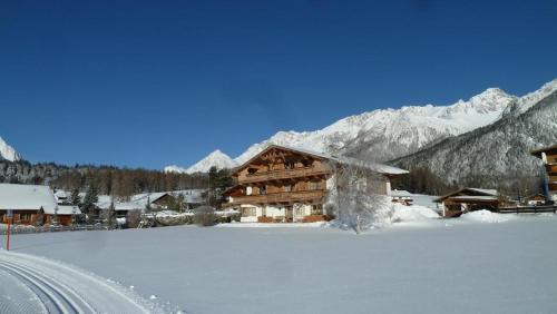 a log cabin in the snow next to a road at Haus Witting in Leutasch