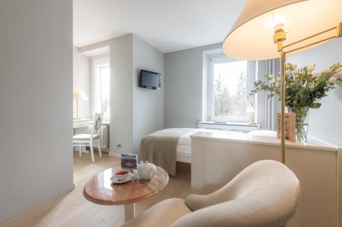 a bedroom with a bed and a table with a chair at Romantik Hotel Schweizerhof & Spa Flims in Flims