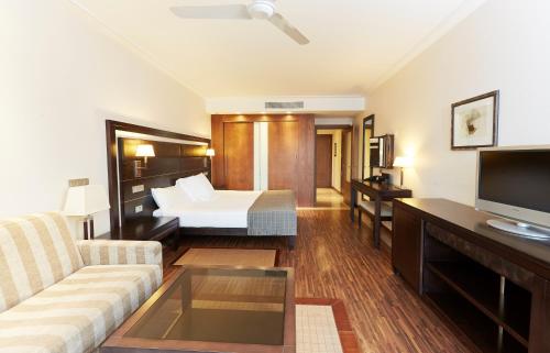 a living room with a couch and a bed at Insotel Fenicia Prestige Suites & Spa in Santa Eularia des Riu