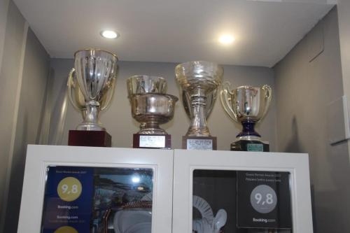 four trophies are on top of a cabinet at B&B Pescara Centro Luxury Suite in Pescara