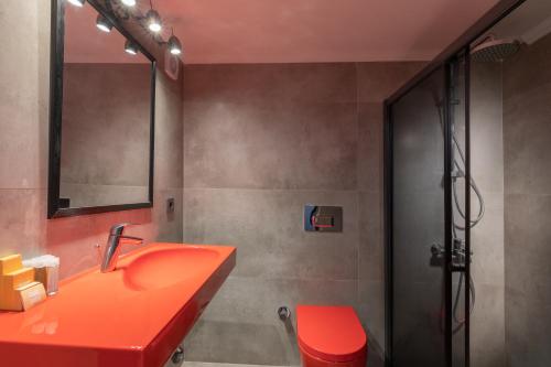アラカティにあるGalano Suites Alacatiのバスルーム(赤いシンク、シャワー付)