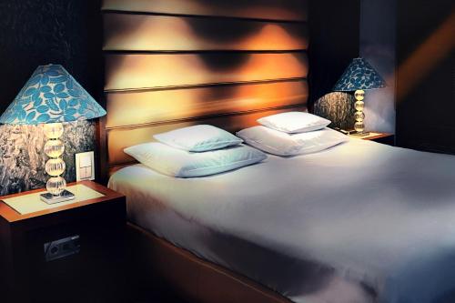 a bedroom with a large white bed with two lamps at Yours Truly in Munich