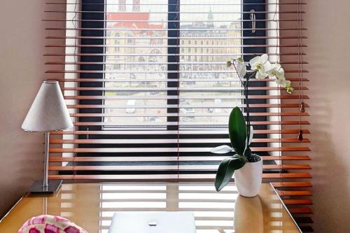 a vase of flowers on a table in front of a window at Yours Truly in Munich