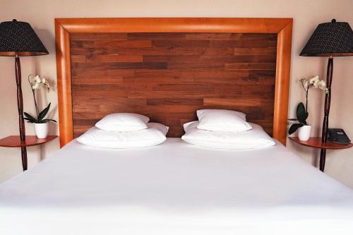 a large bed with two pillows and two lamps at Yours Truly in Munich