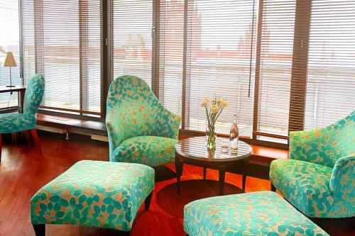 a room with chairs and a table with flowers on it at Yours Truly in Munich