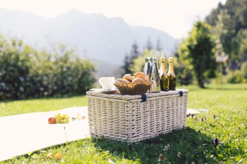 a picnic basket with food and bottles of wine at Hotel Ritzlerhof - Panorama und Spa in Sautens