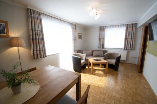 a living room with a couch and a table at Hotel und Berggasthof Tanzbuche in Friedrichroda