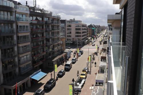 a busy city street with cars parked on the road at Studio Belle Vue in Koksijde