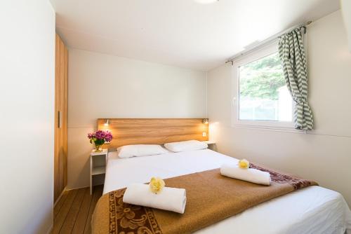 a bedroom with a bed with two towels on it at Club del Sole Due Laghi Levico Family Collection in Levico Terme