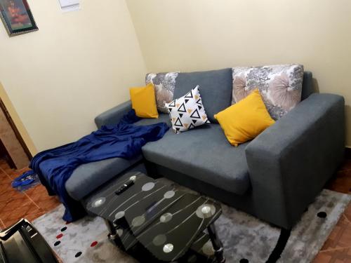 a blue couch with pillows on it in a living room at Rubi Apartment in Naivasha