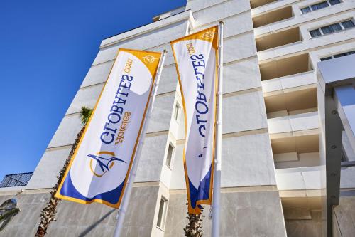 two flags in front of a building at Globales Cala Viñas Adults Only 16+ in Cala Vinyes