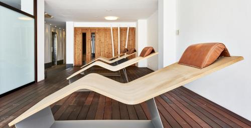 a living room with several chairs on a wooden floor at Globales Cala Viñas Adults Only 16+ in Cala Vinyes