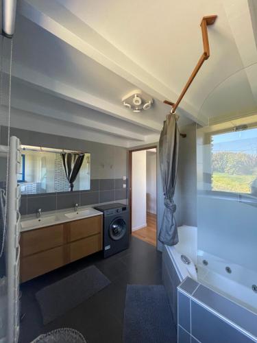 ein Bad mit einer Waschmaschine und einem Trockner im Zimmer in der Unterkunft Le Courlis in Guimaëc