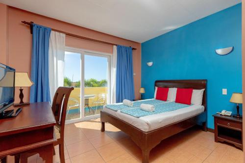 sypialnia z łóżkiem, biurkiem i oknem w obiekcie Ovemar Resort Hotel w mieście Vigan