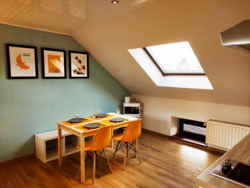 a dining room with a table and a skylight at Lacs de l'eau d'heure Chez Oma in Cerfontaine