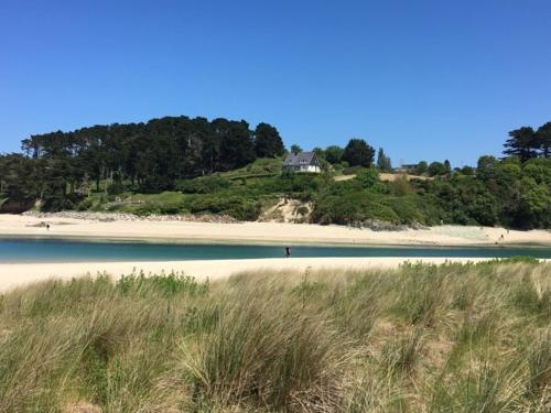 a beach with a house on top of a hill at Le Courlis in Guimaëc