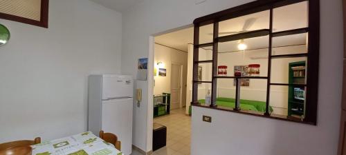 una cucina con frigorifero e una camera con tavolo di Casa Praiola a Terrasini