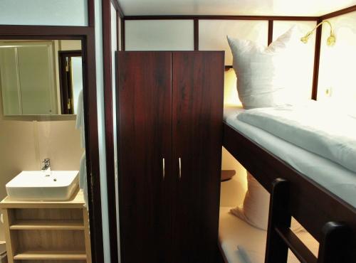 sypialnia z łóżkiem piętrowym i umywalką w obiekcie Alexander von Humboldt - Das Schiff w Bremie