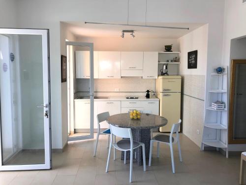 La cuisine est équipée d'une table, de chaises et d'un réfrigérateur. dans l'établissement Villa Ani, à Villanova di Ostuni